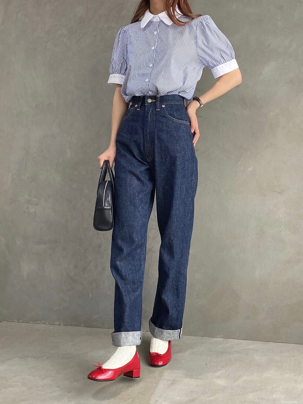 ブルー系のシャツ/ブラウス、ブラック系のボストンバッグ、ブルー系のデニムパンツを着用したレディースの春コーディネートの4枚目の写真