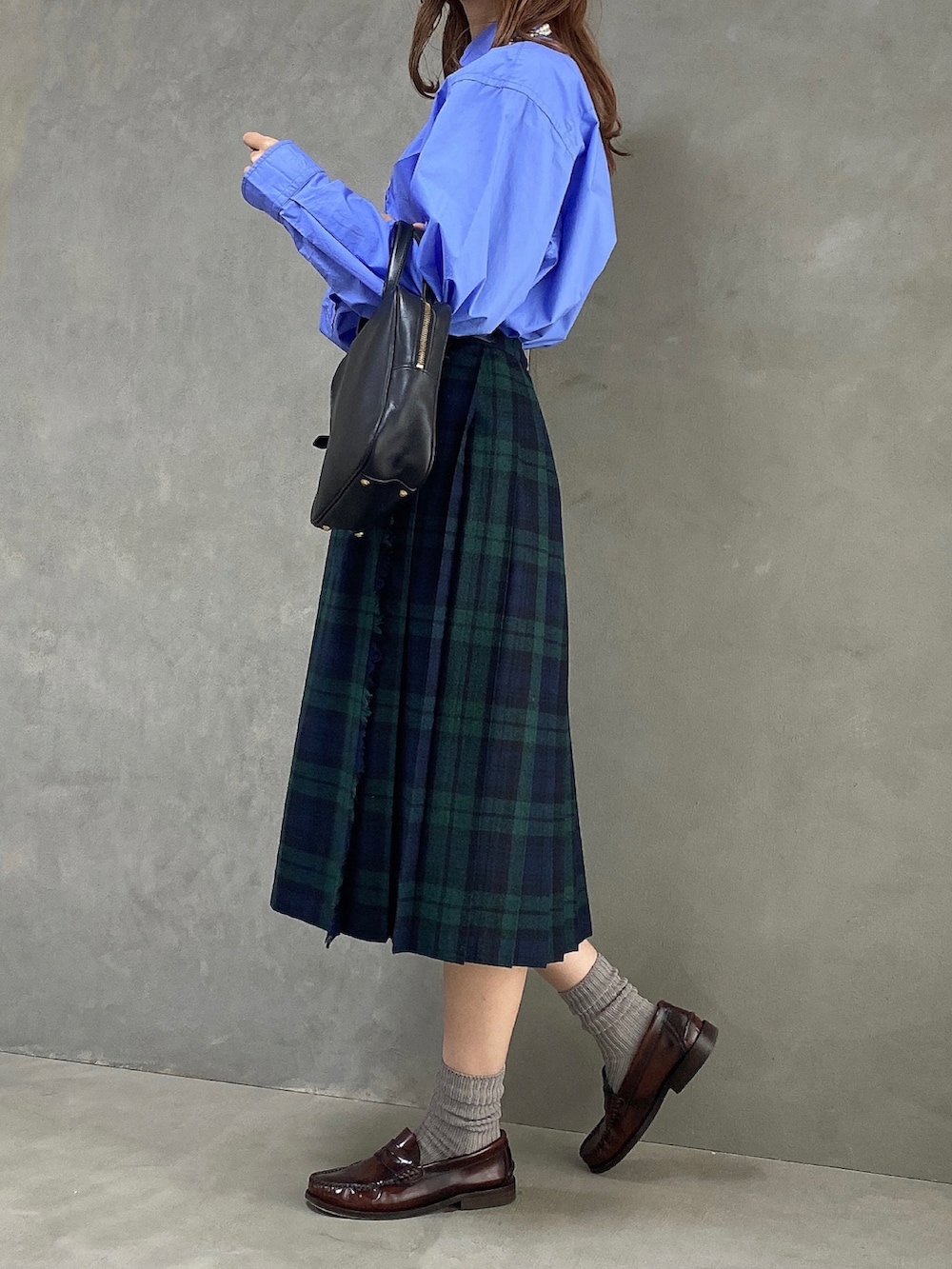 ブルー系のシャツ/ブラウス、ブラック系のハンドバッグ、ブラック系のスカートを着用したレディースの春コーディネートの2枚目の写真