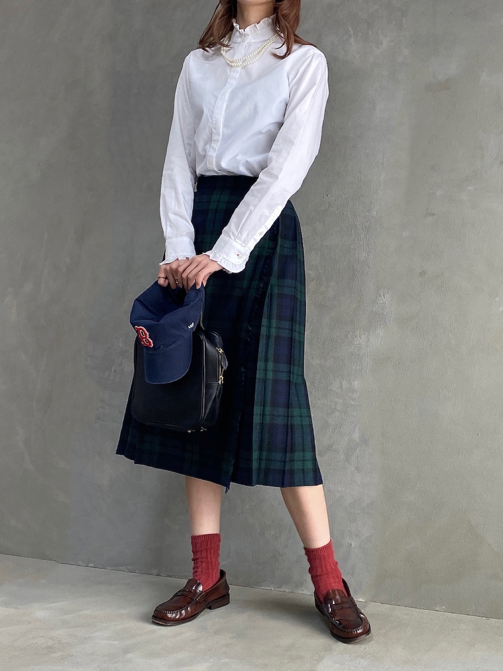 ブラック系のハンドバッグ、ホワイト系のシャツ/ブラウス、ブラック系のスカートを着用したレディースの春コーディネートの2枚目の写真