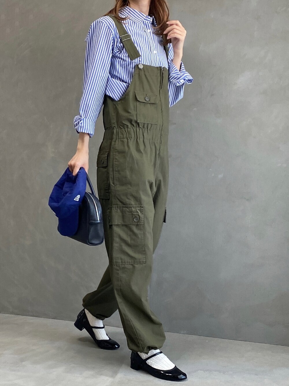 ブラック系のボストンバッグ、ブラック系のパンプス、ブルー系のシャツ/ブラウスを着用したレディースの春コーディネートの3枚目の写真