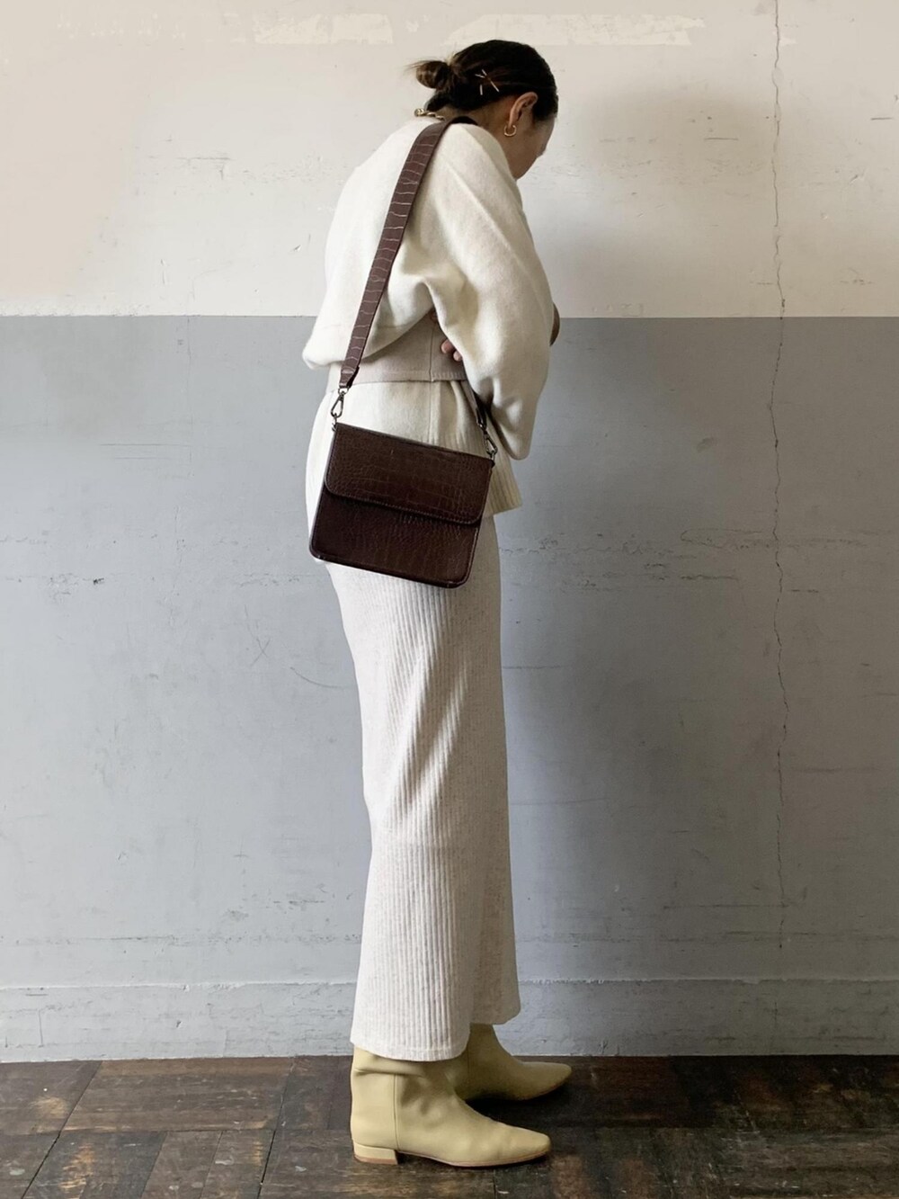 ホワイト系のニット/セーター、ベージュ系のその他トップス、ホワイト系のスカートを着用したレディースの冬コーディネートの4枚目の写真