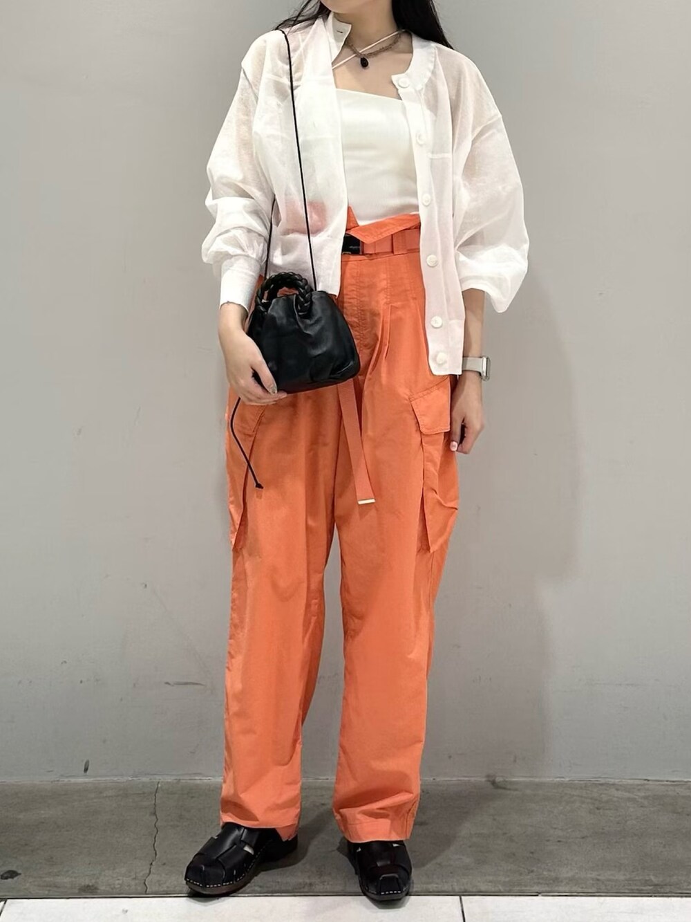 ホワイト系のカーディガン/ボレロ、オレンジ系のカーゴパンツ、ホワイト系のキャミソールを着用したレディースの春コーディネートの2枚目の写真