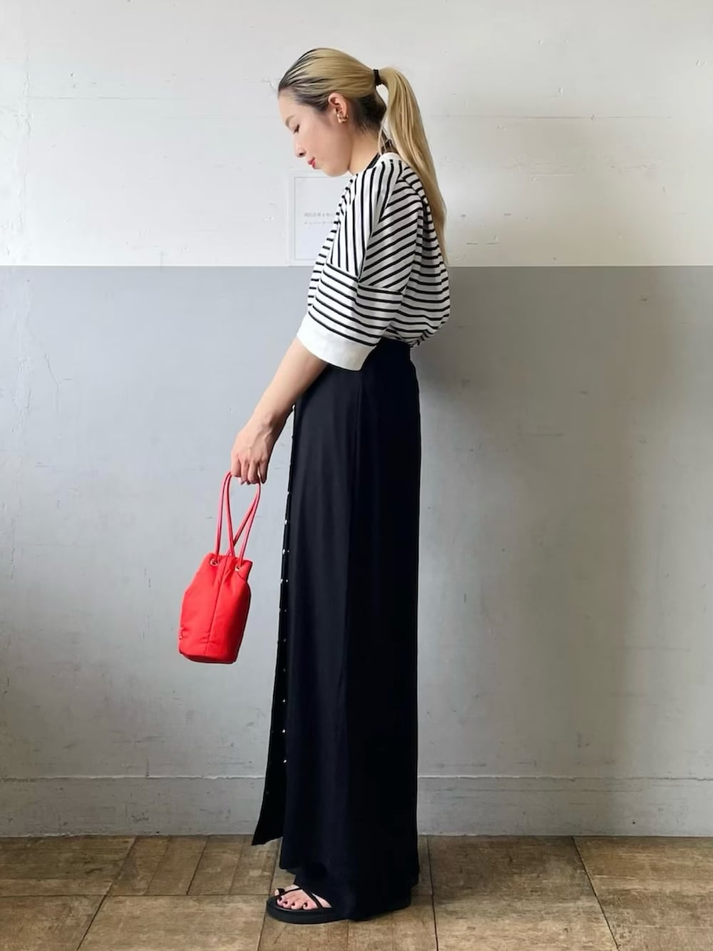 ホワイト系のTシャツ/カットソー、ブラック系のスカート、ブラック系のサンダルを着用したレディースの春コーディネートの3枚目の写真