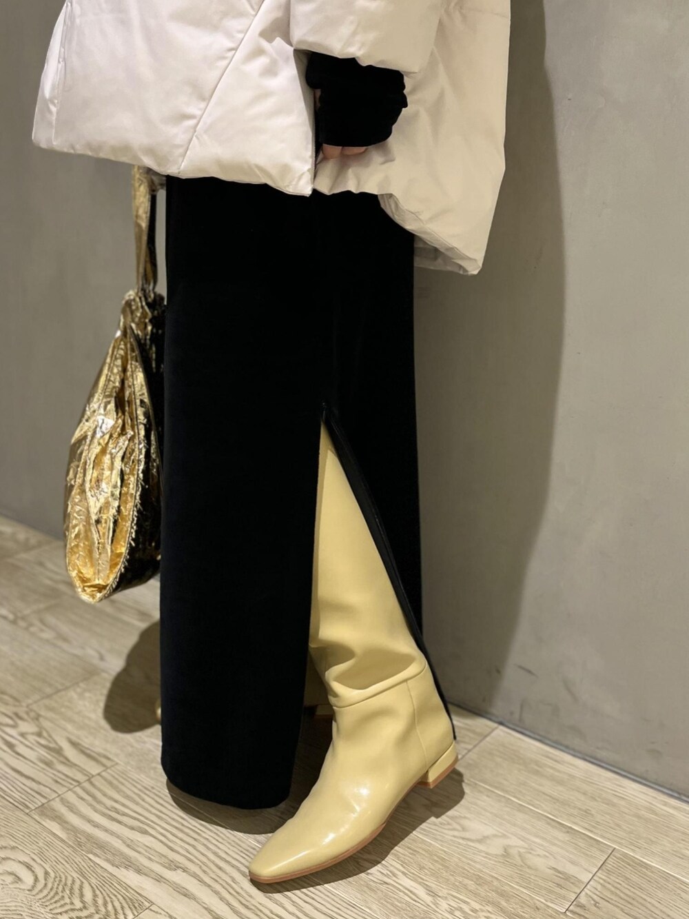 ホワイト系のダウンジャケット/コート、ベージュ系のブーツ、ゴールド系のエコバッグ/サブバッグを着用したレディースの冬コーディネートの4枚目の写真