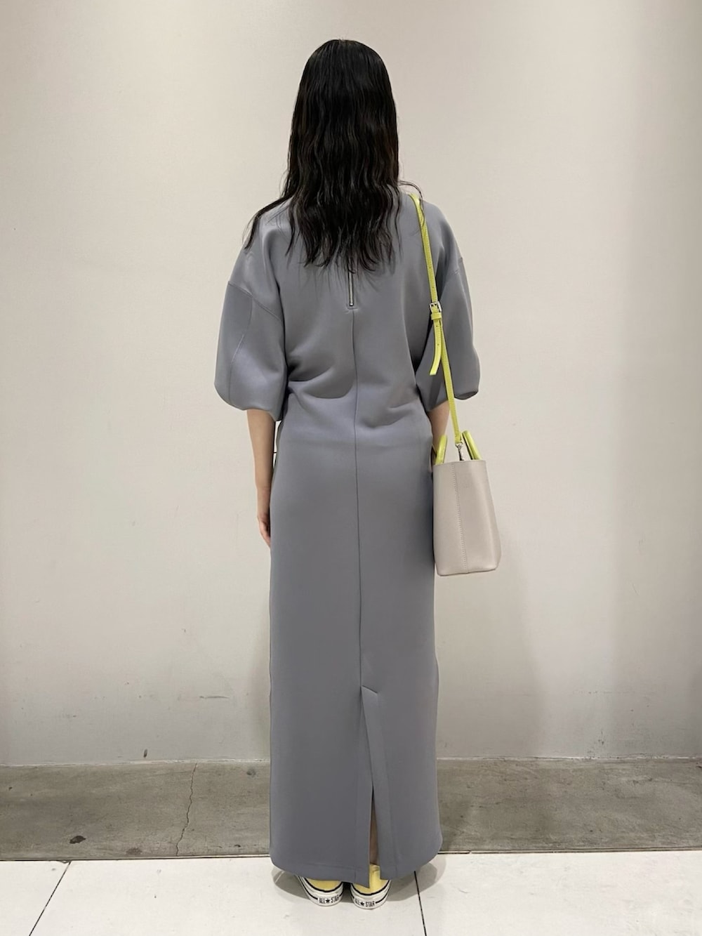 グレー系のワンピース、イエロー系のスニーカー、グレー系のショルダーバッグを着用したレディースの春コーディネートの4枚目の写真