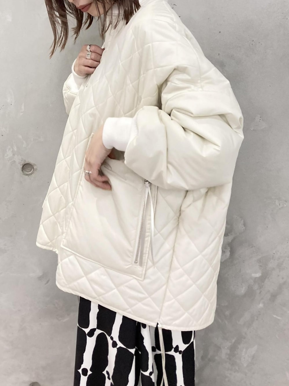 ホワイト系のブルゾン、ブラック系のワンピースを着用したレディースの夏コーディネートの2枚目の写真