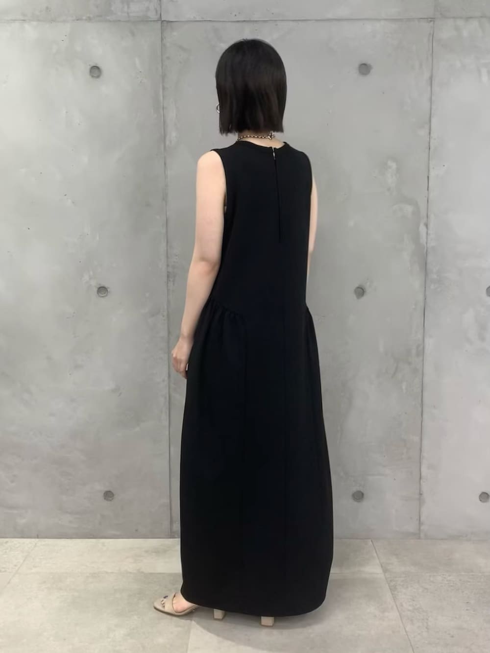 ブラック系のワンピース、ベージュ系のサンダルを着用したレディースの春コーディネートの3枚目の写真