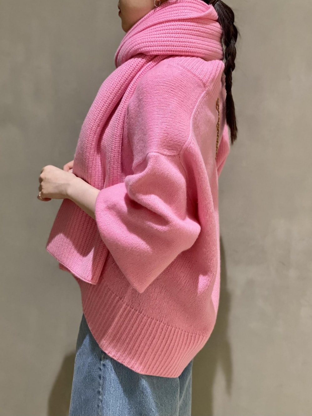 ピンク系のニット/セーター、ピンク系のショルダーバッグ、ブルー系のデニムパンツを着用したレディースの秋コーディネートの4枚目の写真