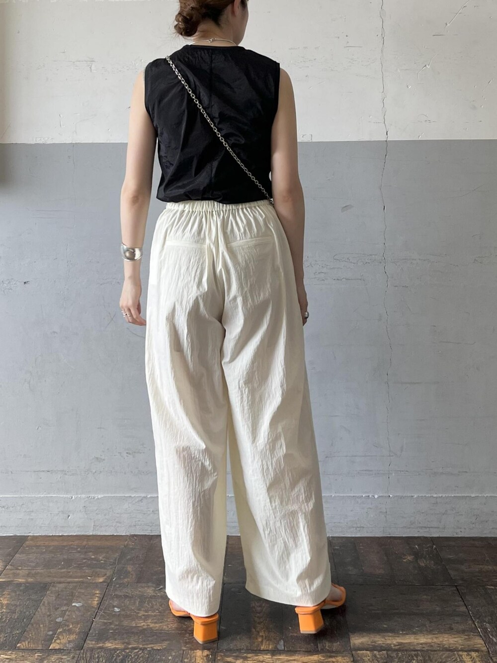 ブラック系のタンクトップ、グレー系のショルダーバッグ、ホワイト系のその他パンツを着用したレディースの夏コーディネートの3枚目の写真