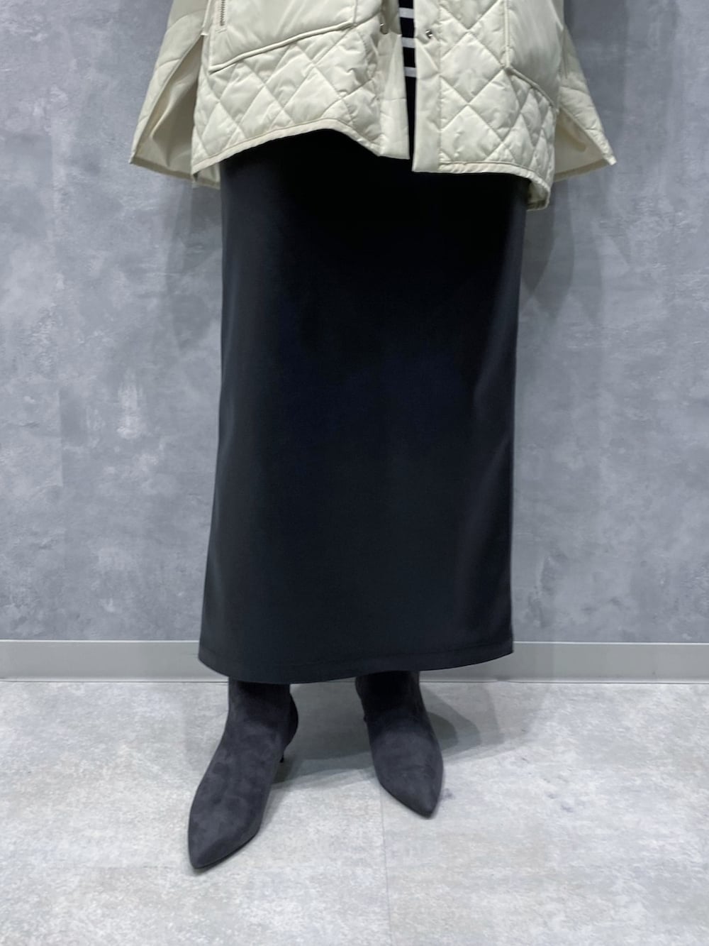 ホワイト系のブルゾン、ブラック系のスカート、グレー系のブーツを着用したレディースの秋コーディネートの5枚目の写真