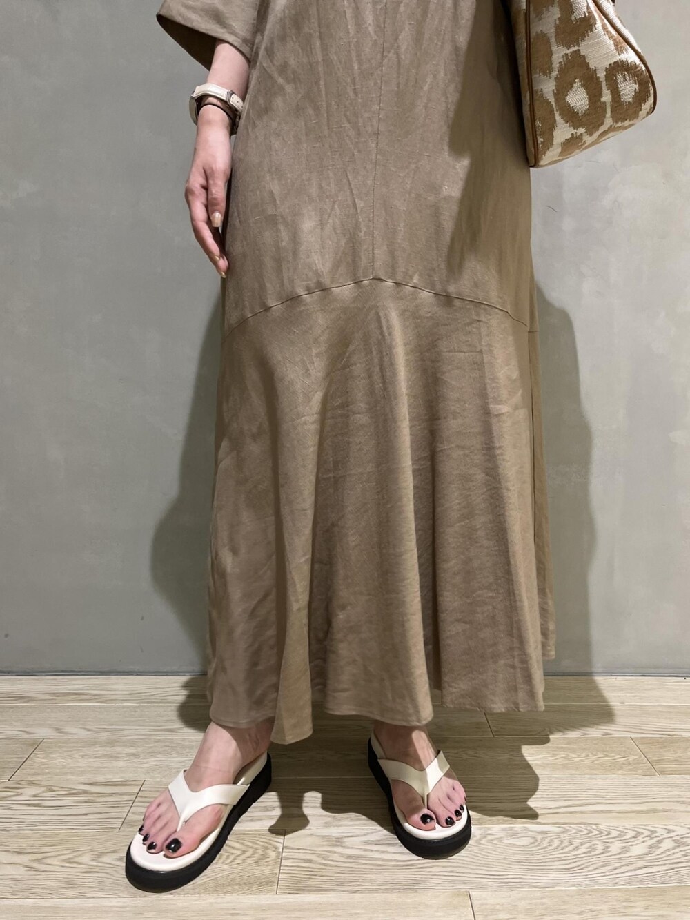 ベージュ系のワンピース、ホワイト系のサンダル、ホワイト系のタンクトップを着用したレディースの夏コーディネートの4枚目の写真