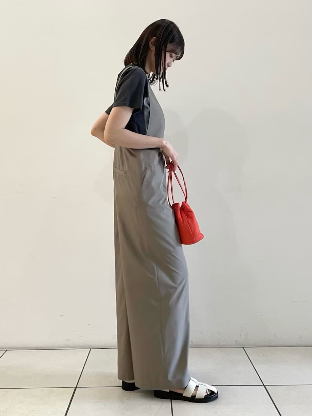ベージュ系のサロペット/オーバーオール、レッド系のショルダーバッグ、ホワイト系のサンダルを着用したレディースの春コーディネートの2枚目の写真