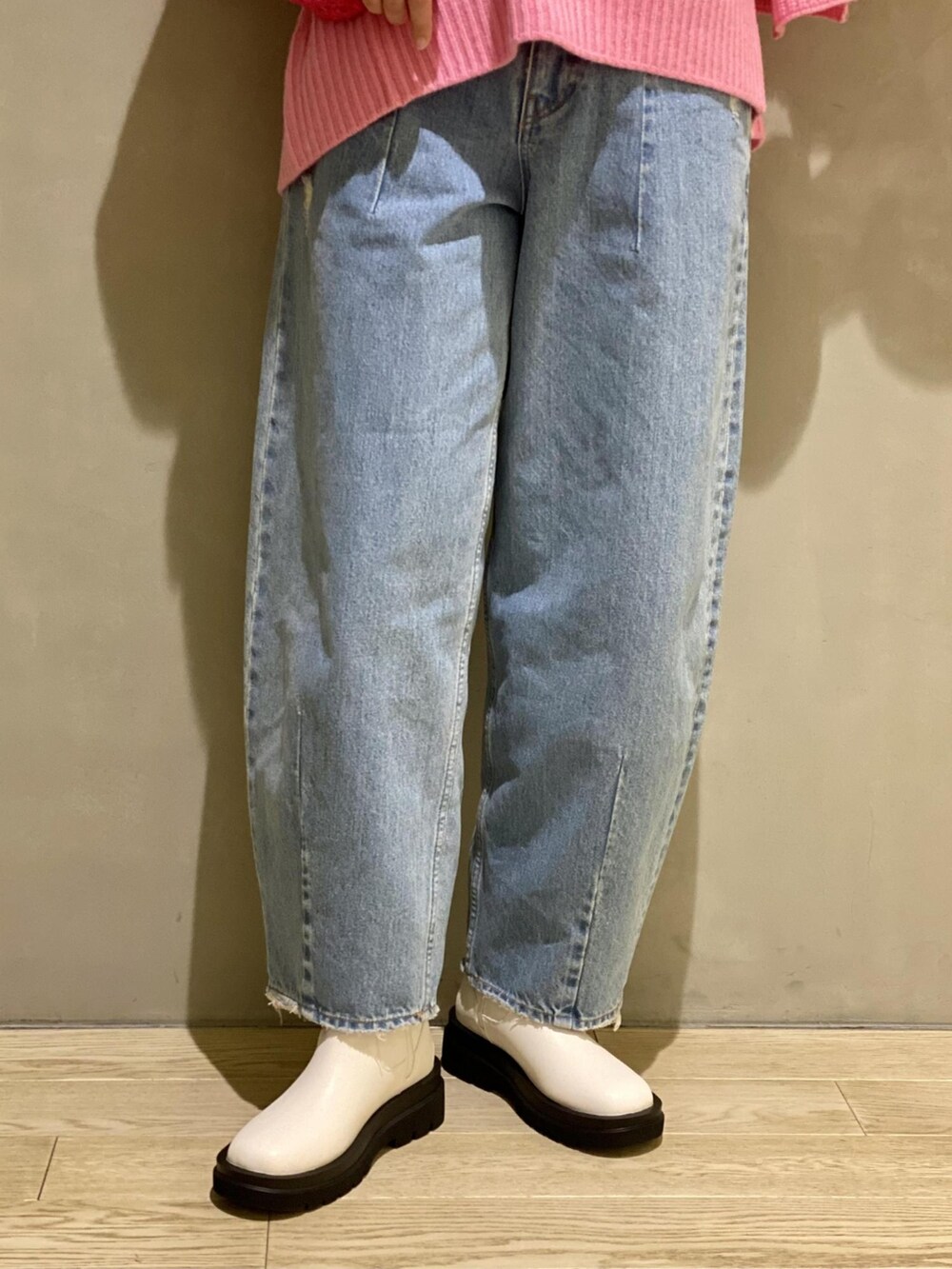 ピンク系のニット/セーター、ピンク系のショルダーバッグ、ブルー系のデニムパンツを着用したレディースの秋コーディネートの5枚目の写真