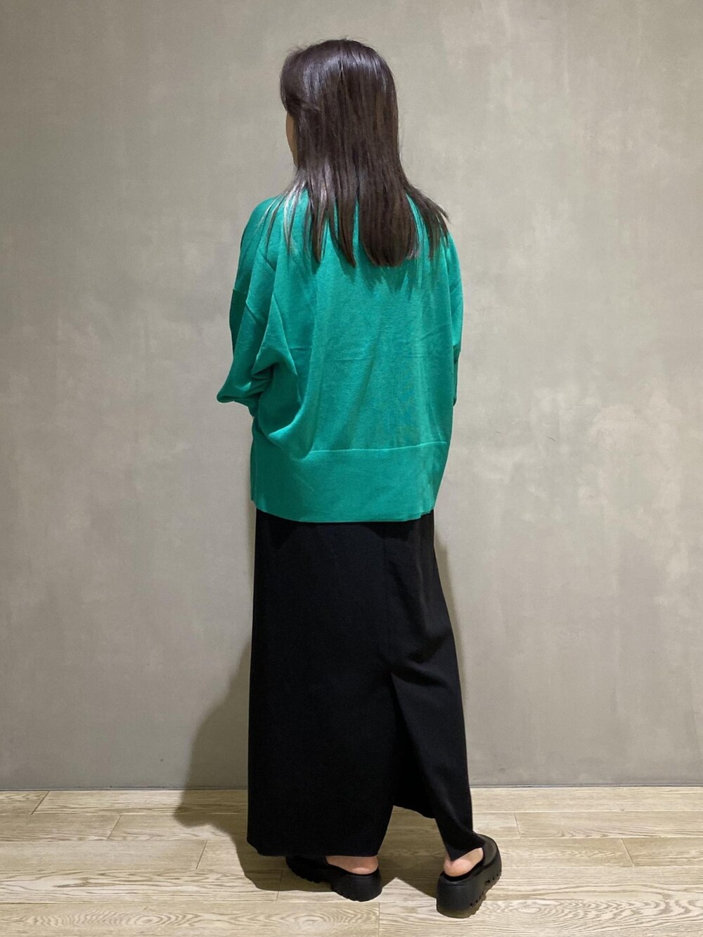 グリーン系のカーディガン/ボレロ、ブラック系のバッグ、ブラック系のワンピースを着用したレディースの夏コーディネートの2枚目の写真