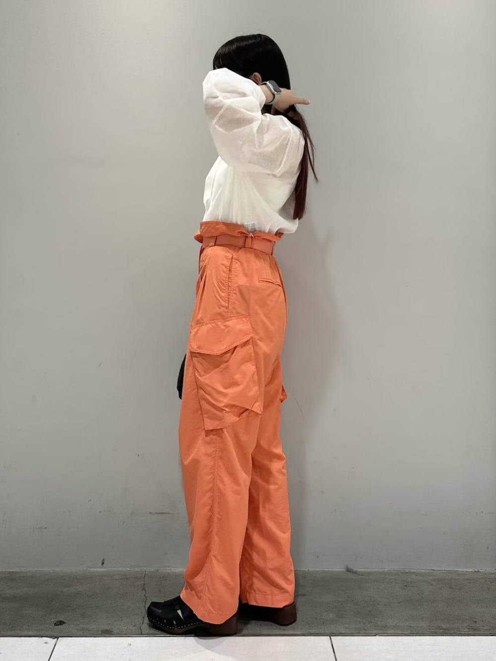 ホワイト系のカーディガン/ボレロ、オレンジ系のカーゴパンツ、ホワイト系のキャミソールを着用したレディースの春コーディネートの4枚目の写真