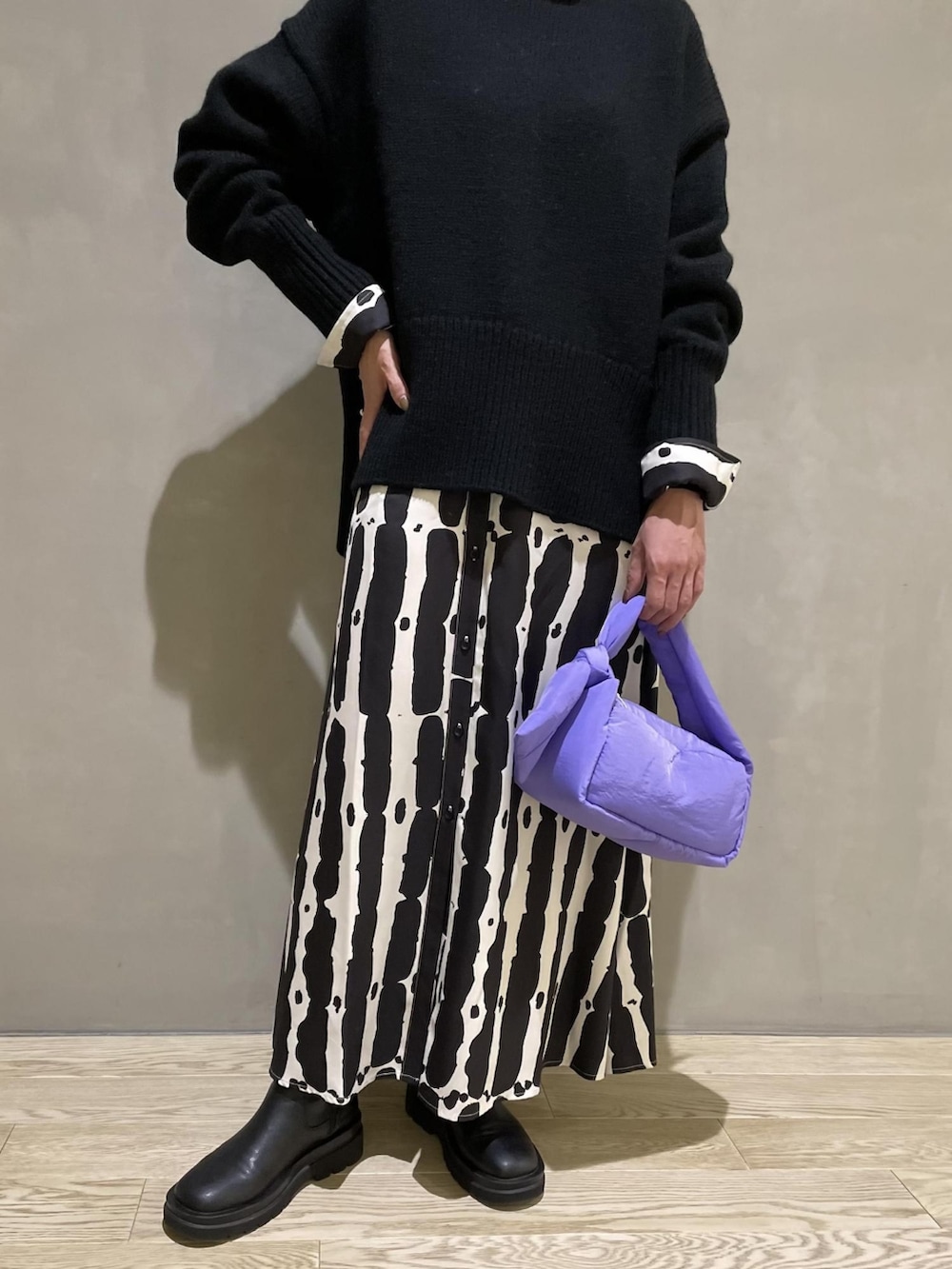 ブラック系のニット/セーター、パープル系のハンドバッグ、ブラック系のワンピースを着用したレディースの夏コーディネートの4枚目の写真