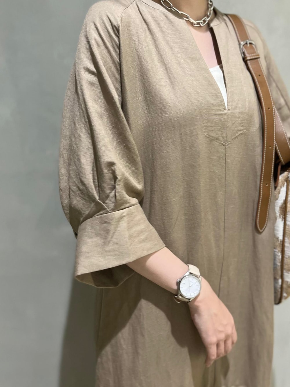 ベージュ系のワンピース、ホワイト系のサンダルを着用したレディースの春コーディネートの3枚目の写真