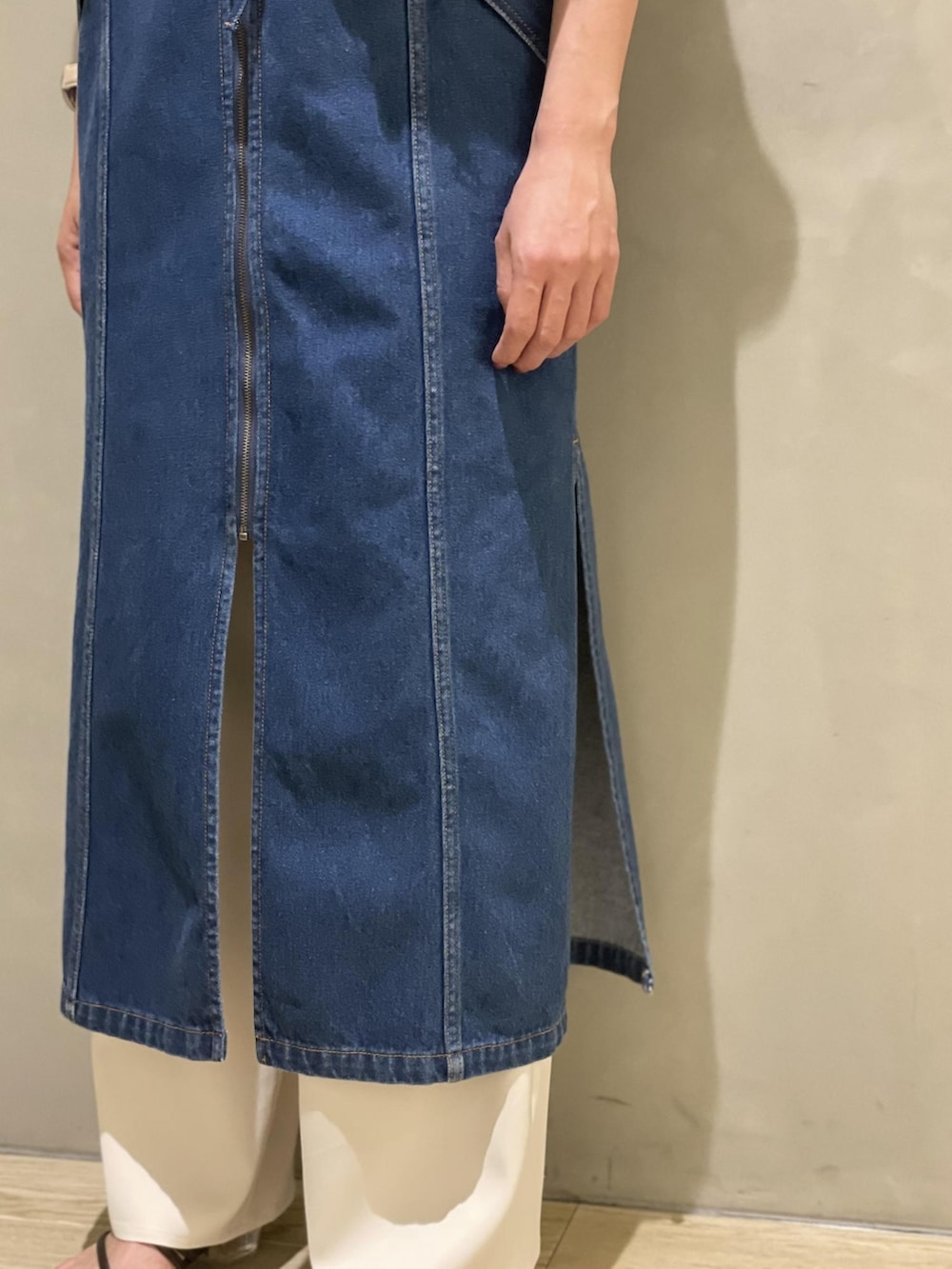 ブルー系のジャンパースカート、ブラック系のTシャツ/カットソー、ホワイト系のスラックスを着用したレディースの夏コーディネートの4枚目の写真