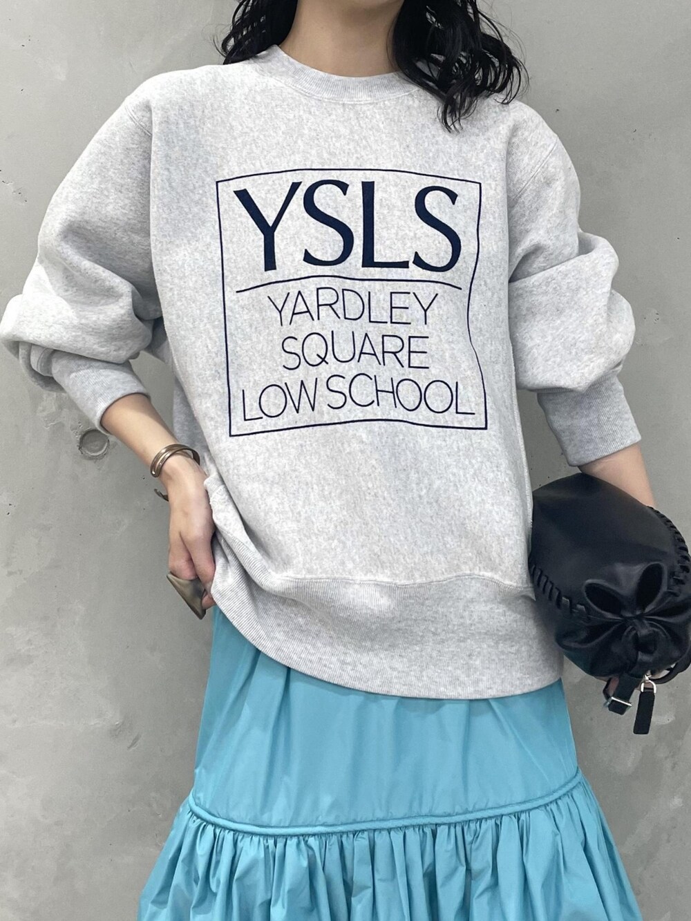 グレー系のスウェット、ブルー系のスカート、ブラック系のブーツを着用したレディースの夏コーディネートの3枚目の写真