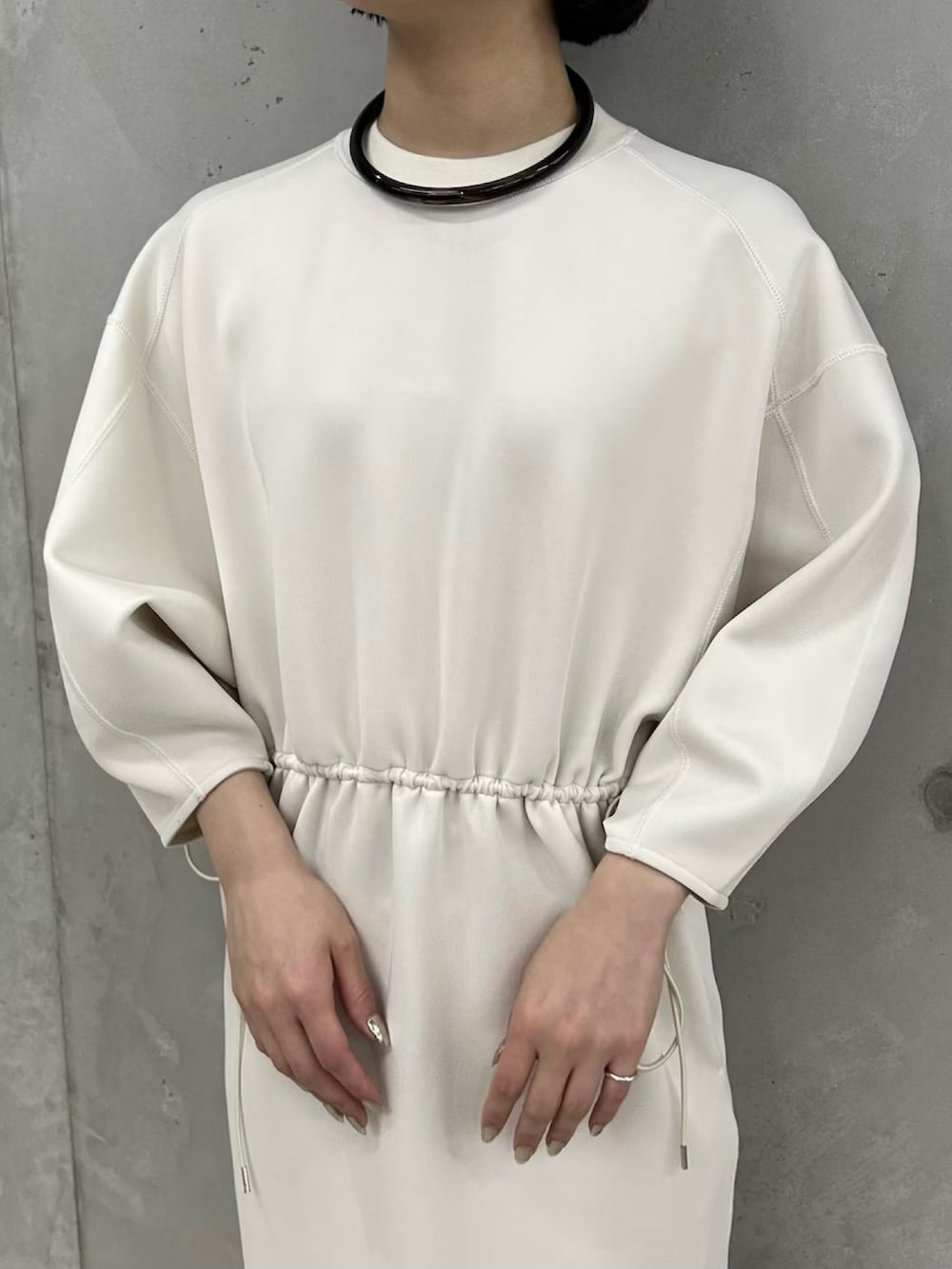 ホワイト系のワンピース、ブラック系のサンダルを着用したレディースの春コーディネートの3枚目の写真