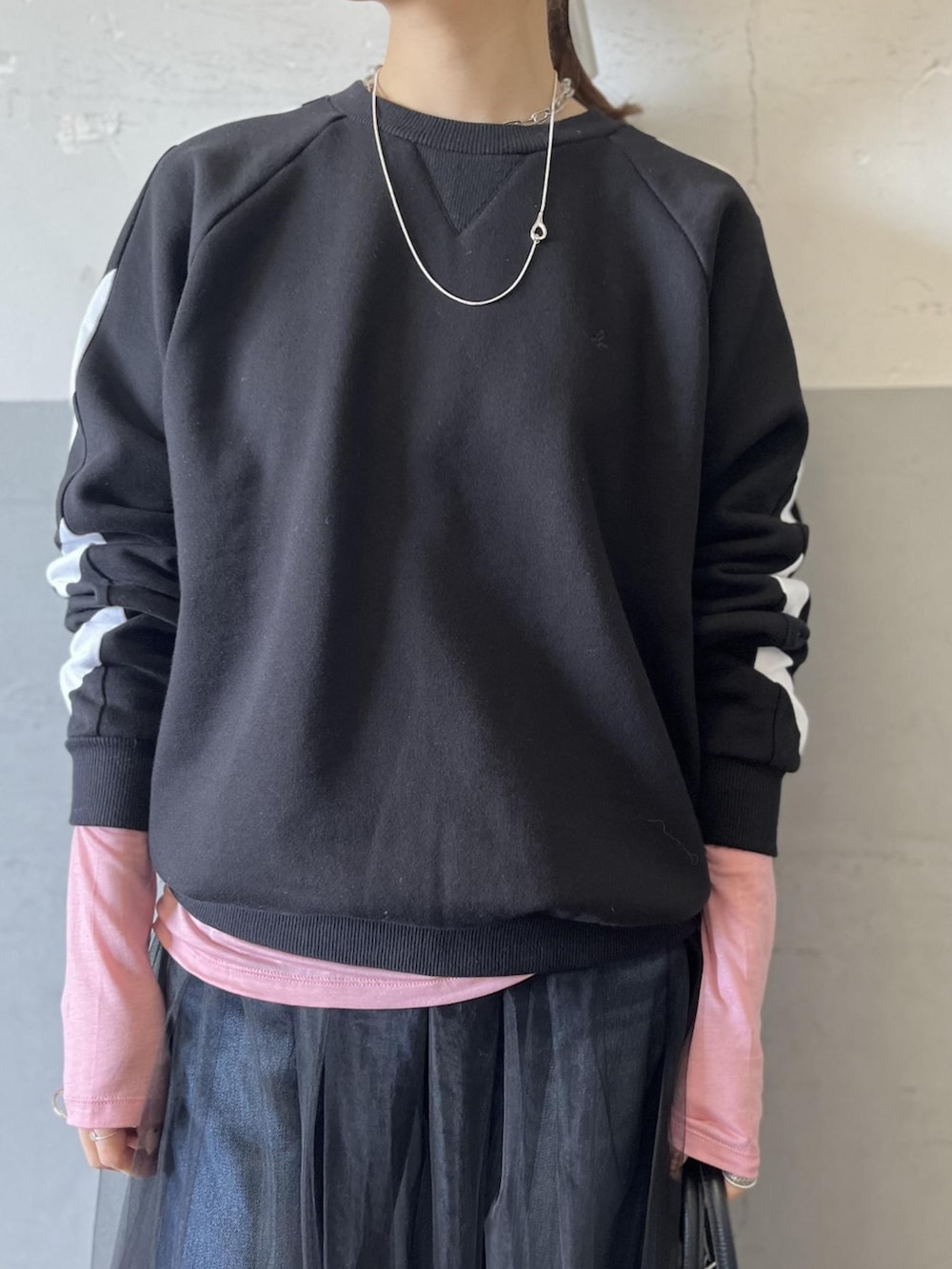 ブラック系のスウェット、ピンク系のTシャツ/カットソー、ブラック系のスカートを着用したレディースの冬コーディネートの4枚目の写真