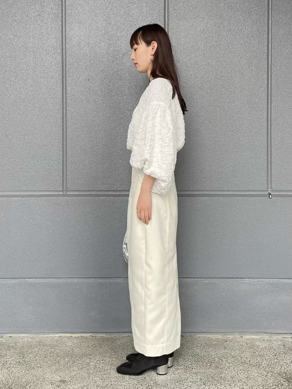 ホワイト系のシャツ/ブラウス、ホワイト系のスカート、ブラック系のブーツを着用したレディースの春コーディネートの3枚目の写真