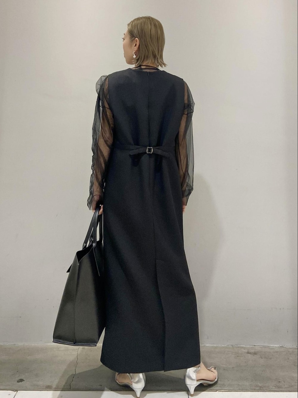 ブラック系のワンピース、ブラック系のTシャツ/カットソー、ブラック系のトートバッグを着用したレディースの春コーディネートの3枚目の写真