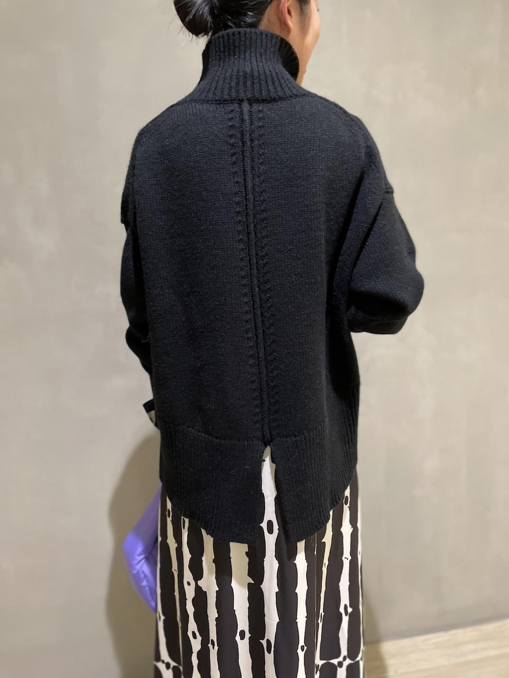 ブラック系のニット/セーター、パープル系のハンドバッグ、ブラック系のワンピースを着用したレディースの夏コーディネートの2枚目の写真