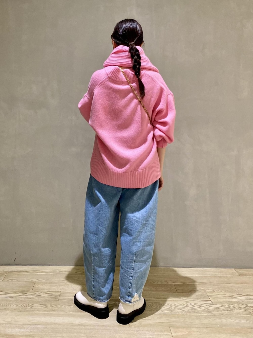 ピンク系のニット/セーター、ピンク系のショルダーバッグ、ブルー系のデニムパンツを着用したレディースの秋コーディネートの3枚目の写真