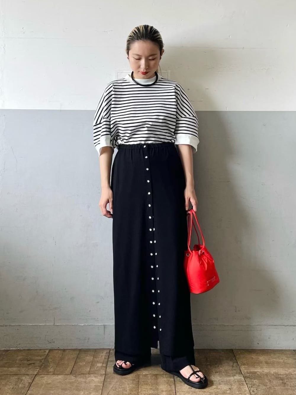 ホワイト系のTシャツ/カットソー、ブラック系のスカート、ブラック系のサンダルを着用したレディースの春コーディネートの2枚目の写真