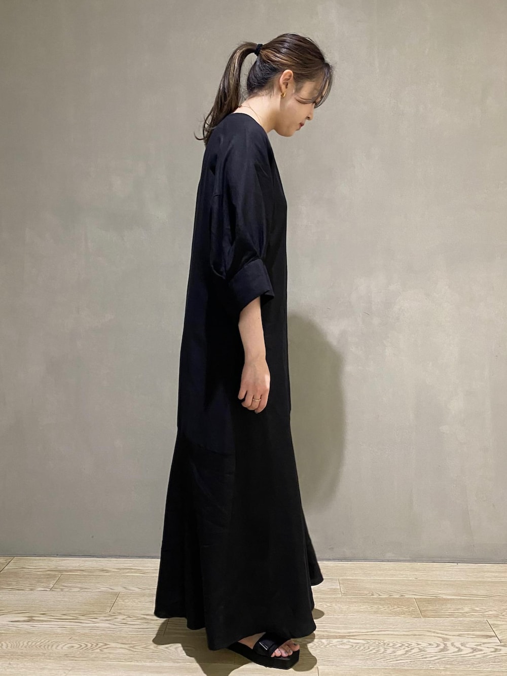 ブラック系のワンピース、ブラック系のサンダルを着用したレディースの春コーディネートの3枚目の写真