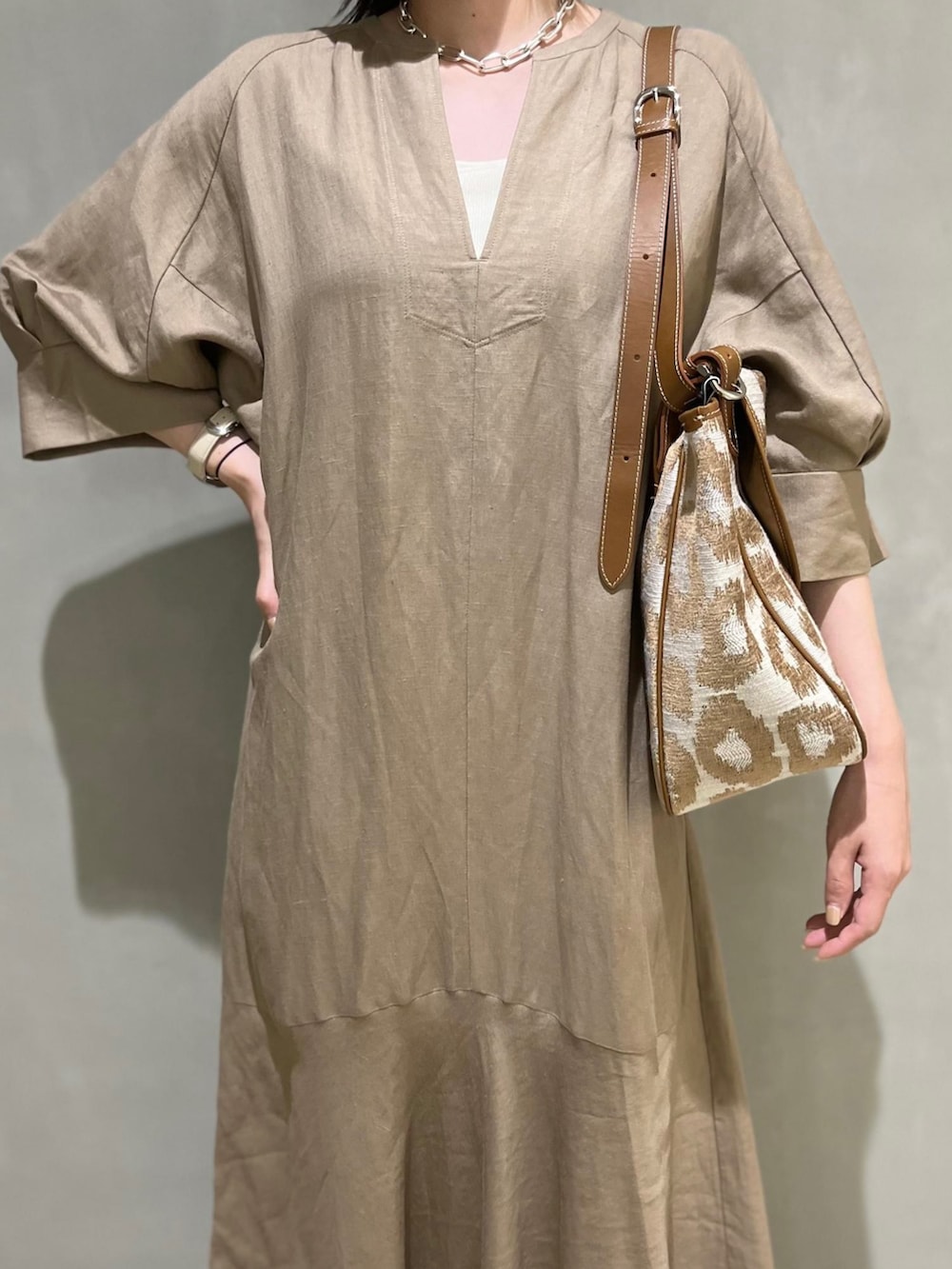 ベージュ系のワンピース、ホワイト系のサンダルを着用したレディースの春コーディネートの2枚目の写真