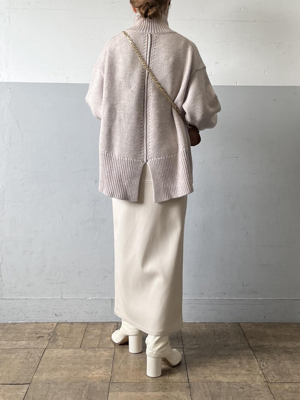 ベージュ系のニット/セーター、イエロー系のショルダーバッグ、ホワイト系のスカートを着用したレディースの夏コーディネートの2枚目の写真