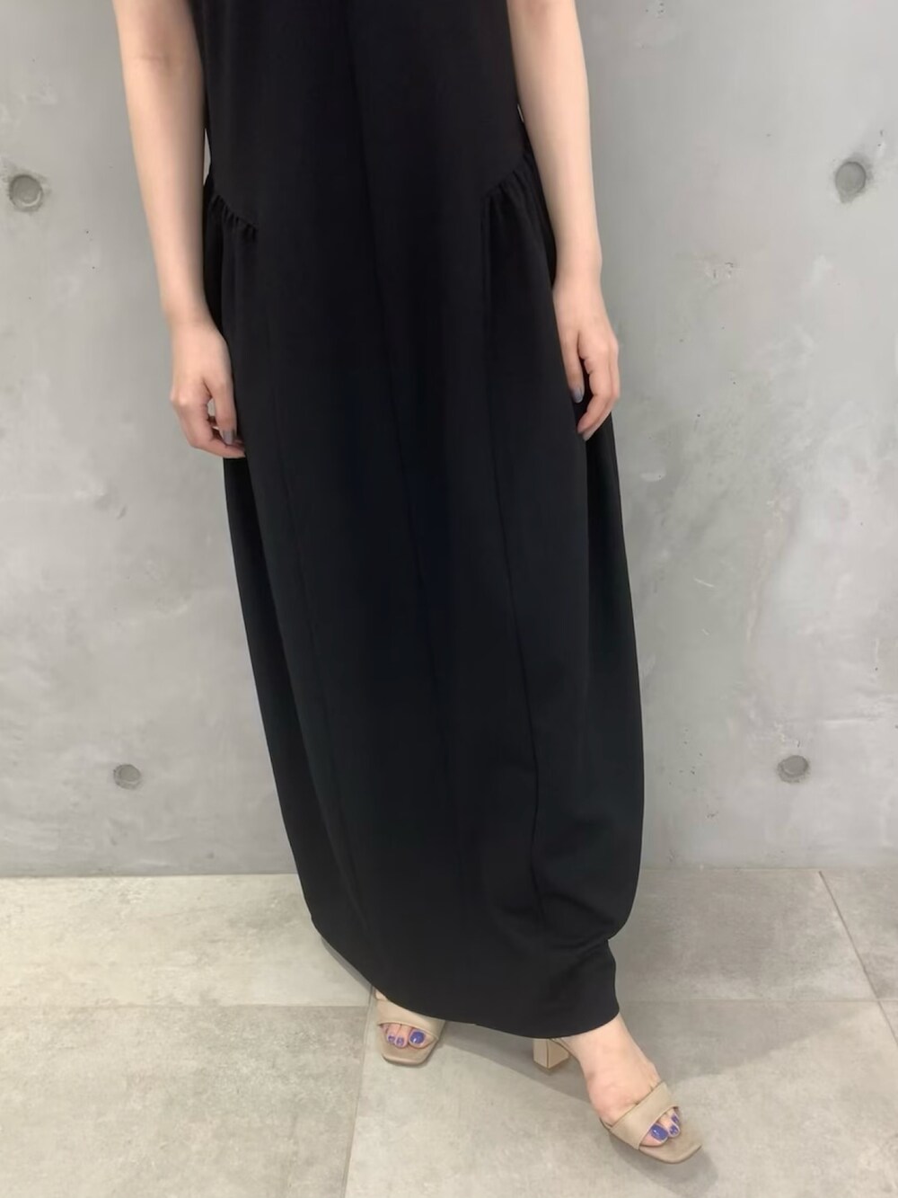 ブラック系のワンピース、ベージュ系のサンダルを着用したレディースの春コーディネートの5枚目の写真