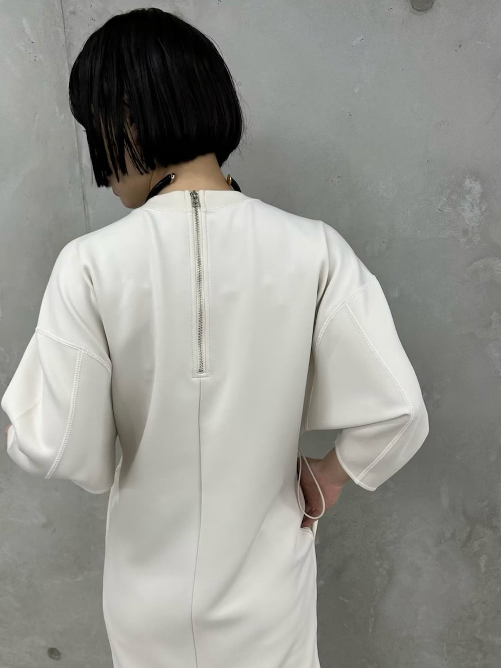 ホワイト系のワンピース、ブラック系のサンダルを着用したレディースの春コーディネートの4枚目の写真