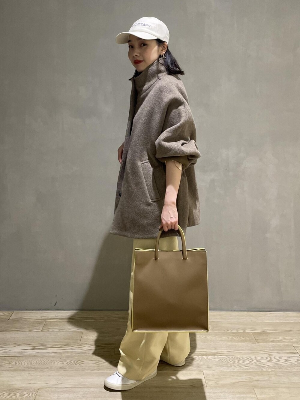 グレー系のその他アウター、ベージュ系のショルダーバッグ、ベージュ系のスラックスを着用したレディースの秋コーディネートの2枚目の写真