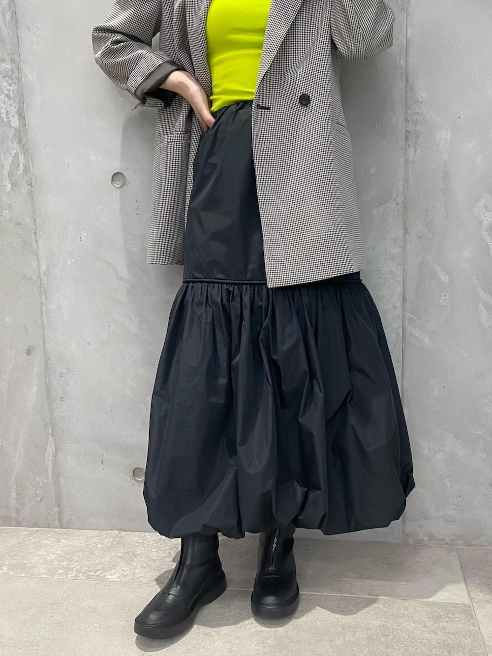 ブラウン系のテーラードジャケット、イエロー系のキャミソール、ブラック系のスカートを着用したレディースの夏コーディネートの4枚目の写真