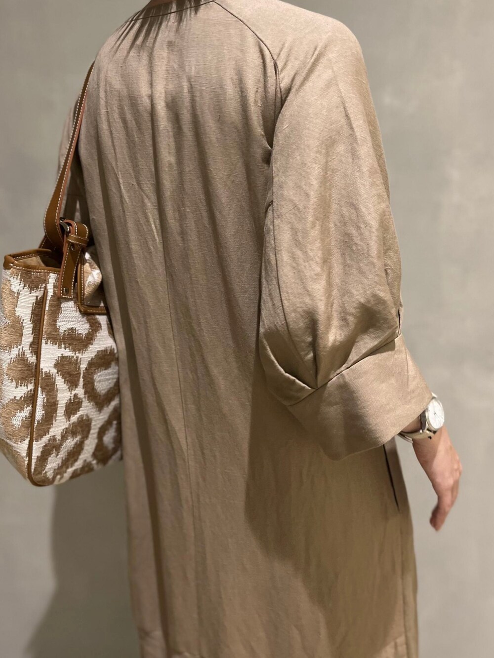 ベージュ系のワンピース、ホワイト系のサンダルを着用したレディースの春コーディネートの4枚目の写真