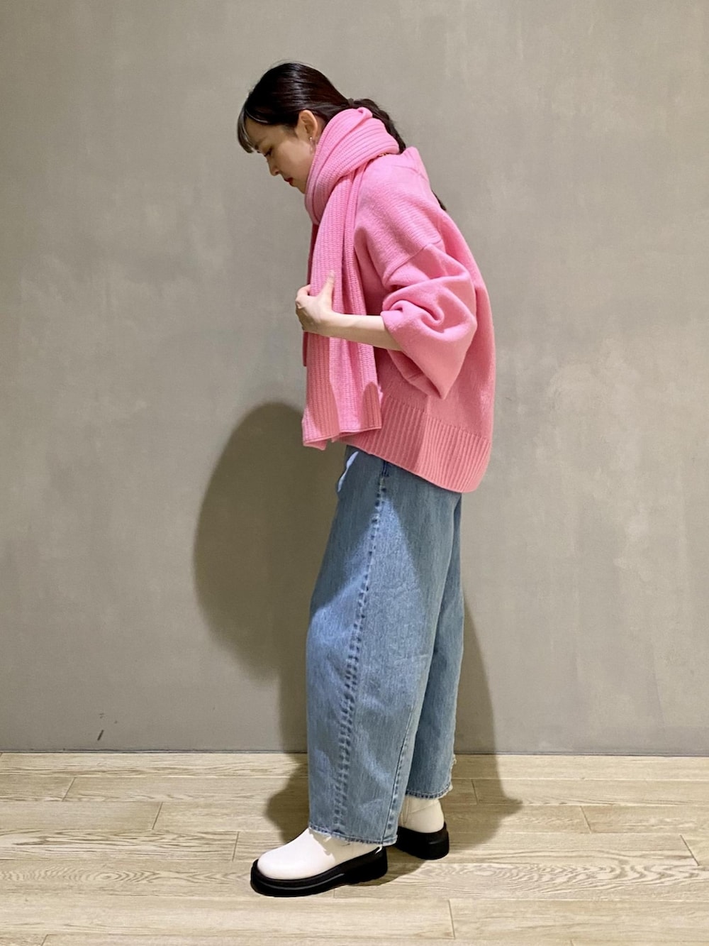 ピンク系のニット/セーター、ピンク系のショルダーバッグ、ブルー系のデニムパンツを着用したレディースの秋コーディネートの2枚目の写真