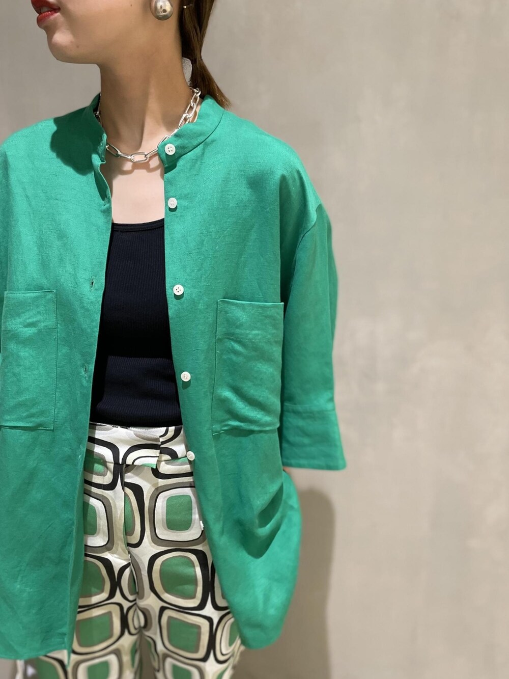 グリーン系のシャツ/ブラウス、ホワイト系のハンドバッグ、ホワイト系のシューズを着用したレディースの夏コーディネートの4枚目の写真