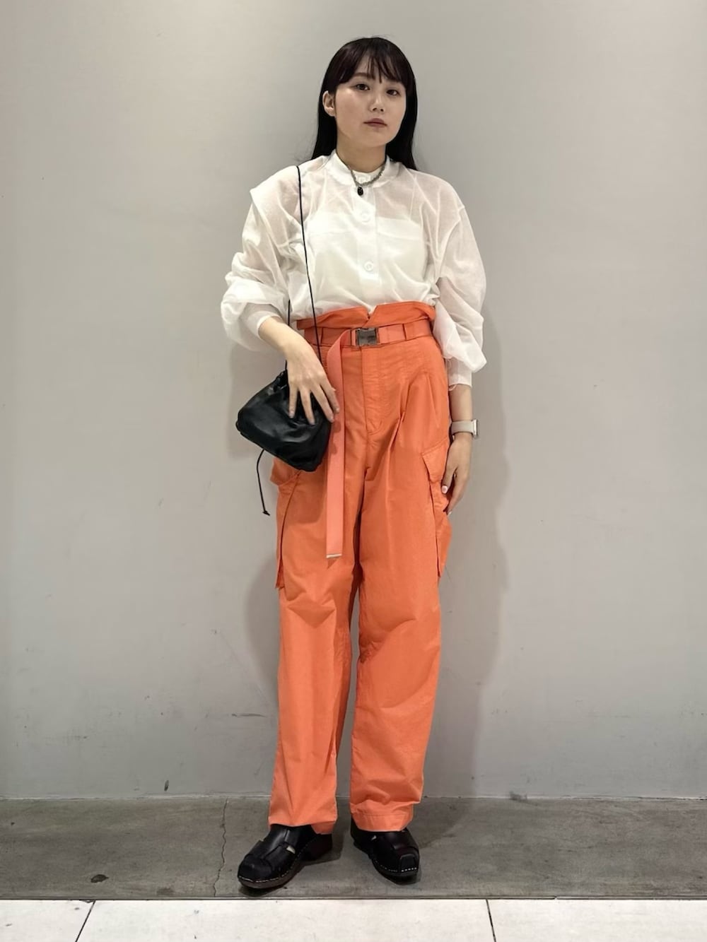ホワイト系のカーディガン/ボレロ、オレンジ系のカーゴパンツ、ホワイト系のキャミソールを着用したレディースの春コーディネートの3枚目の写真