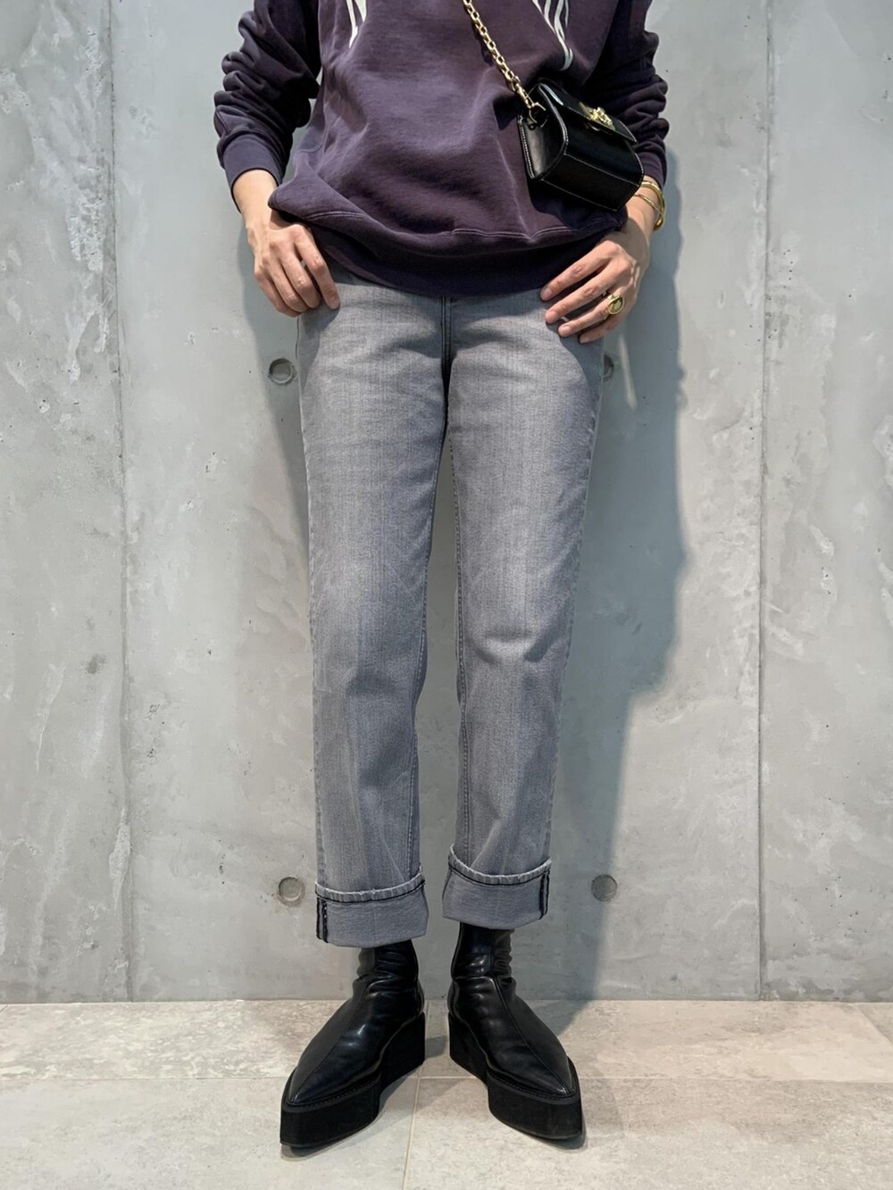 パープル系のスウェット、ブラック系のショルダーバッグ、グレー系のデニムパンツを着用したレディースの夏コーディネートの3枚目の写真