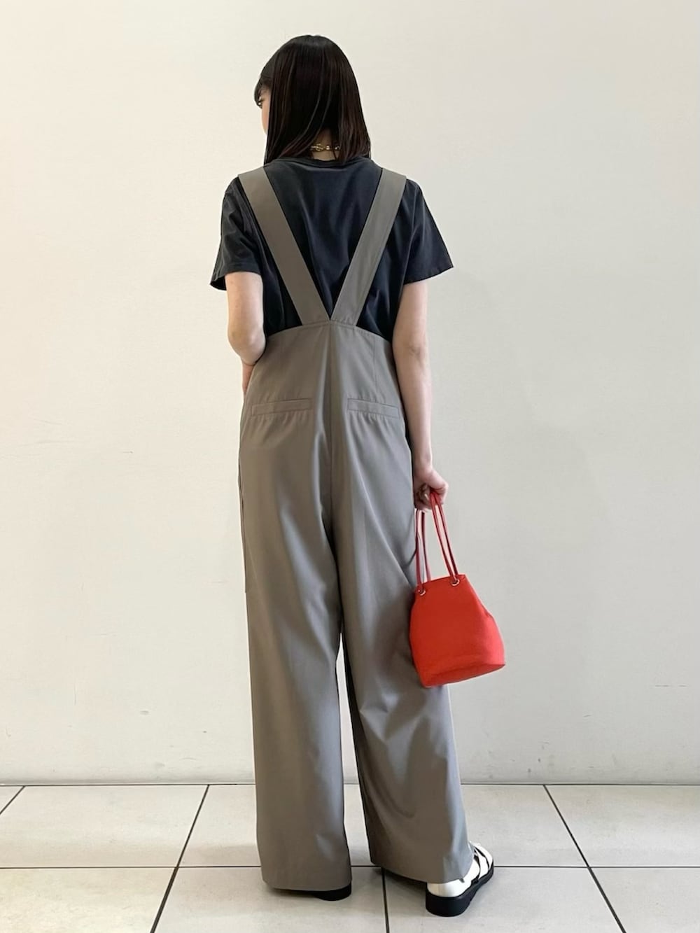 ベージュ系のサロペット/オーバーオール、レッド系のショルダーバッグ、ホワイト系のサンダルを着用したレディースの春コーディネートの3枚目の写真