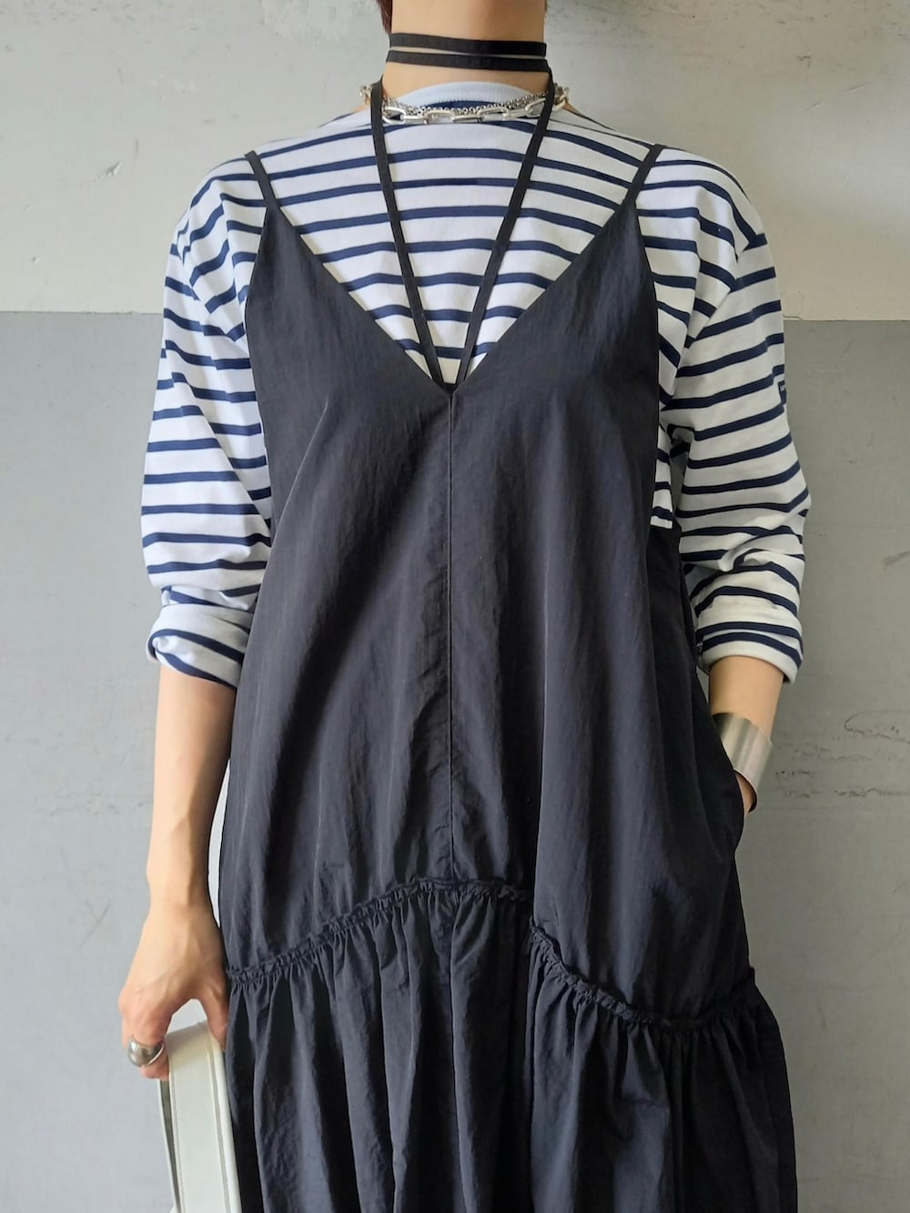 ブラック系のワンピース、ホワイト系のハンドバッグ、イエロー系のスニーカーを着用したレディースの春コーディネートの4枚目の写真