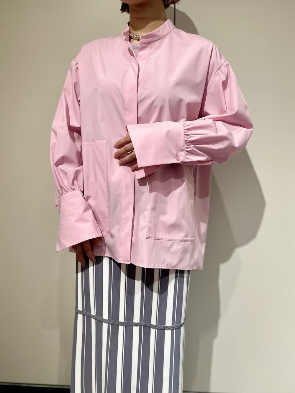 ピンク系のシャツ/ブラウス、グレー系のスカート、ホワイト系のサンダルを着用したレディースの春コーディネートの5枚目の写真