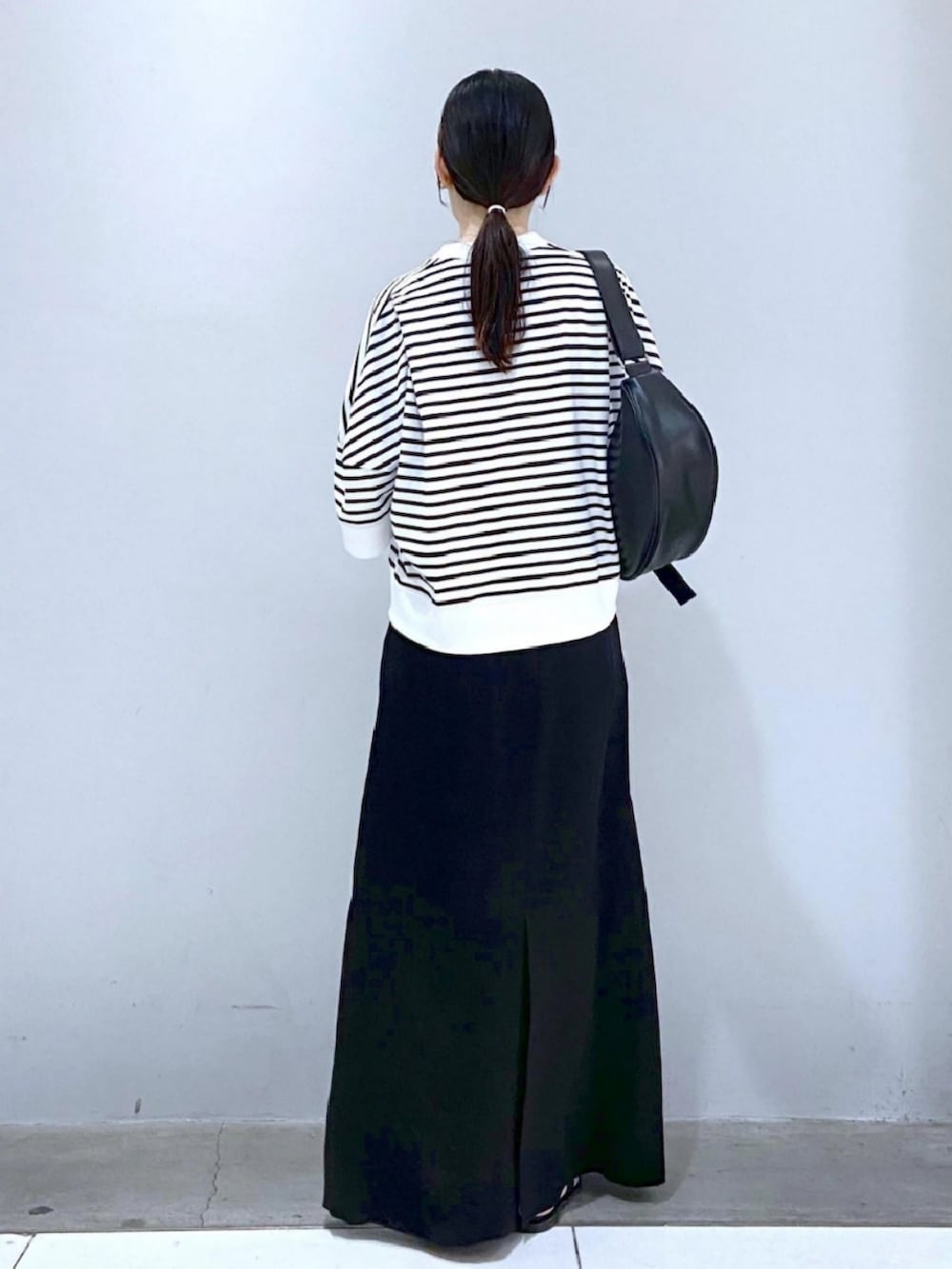 ホワイト系のTシャツ/カットソー、ブラック系のスカート、ブラック系のサンダルを着用したレディースの夏コーディネートの3枚目の写真