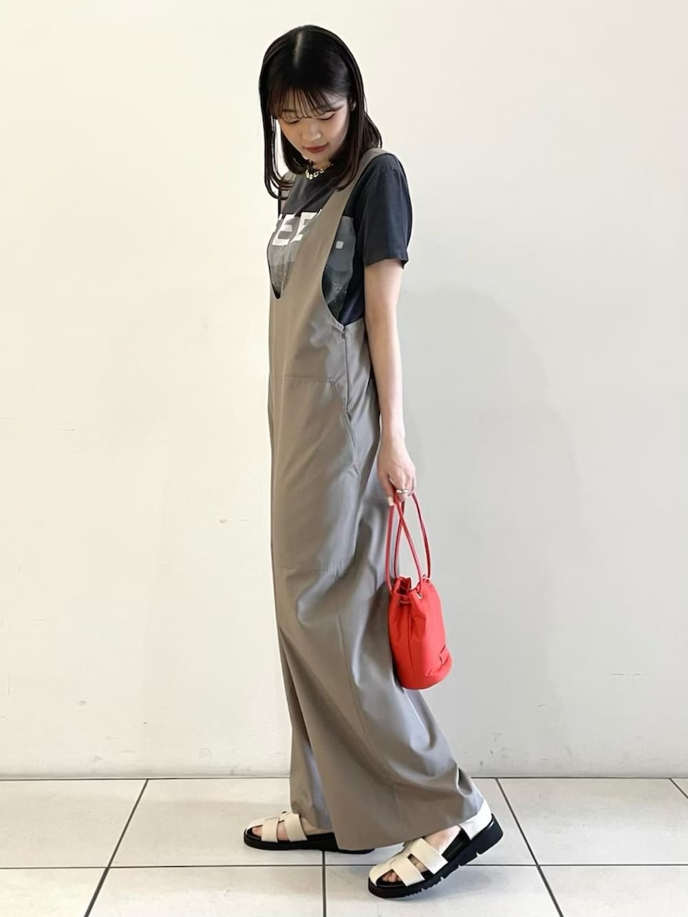 ベージュ系のサロペット/オーバーオール、レッド系のショルダーバッグ、ホワイト系のサンダルを着用したレディースの春コーディネートの4枚目の写真