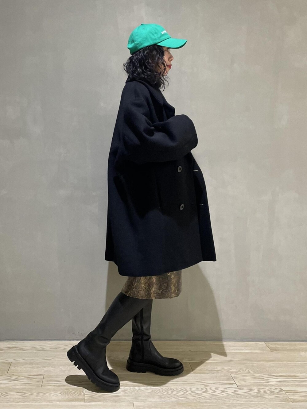 ブラック系のその他アウター、ホワイト系のニット/セーター、ホワイト系のハンドバッグを着用したレディースの冬コーディネートの2枚目の写真