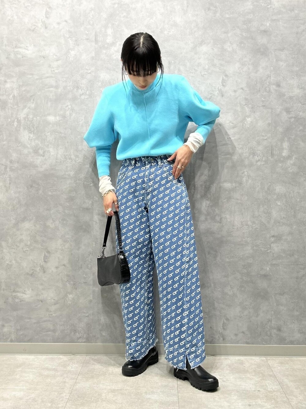 ブルー系のニット/セーター、ホワイト系のTシャツ/カットソー、ブルー系のデニムパンツを着用したレディースの冬コーディネートの2枚目の写真