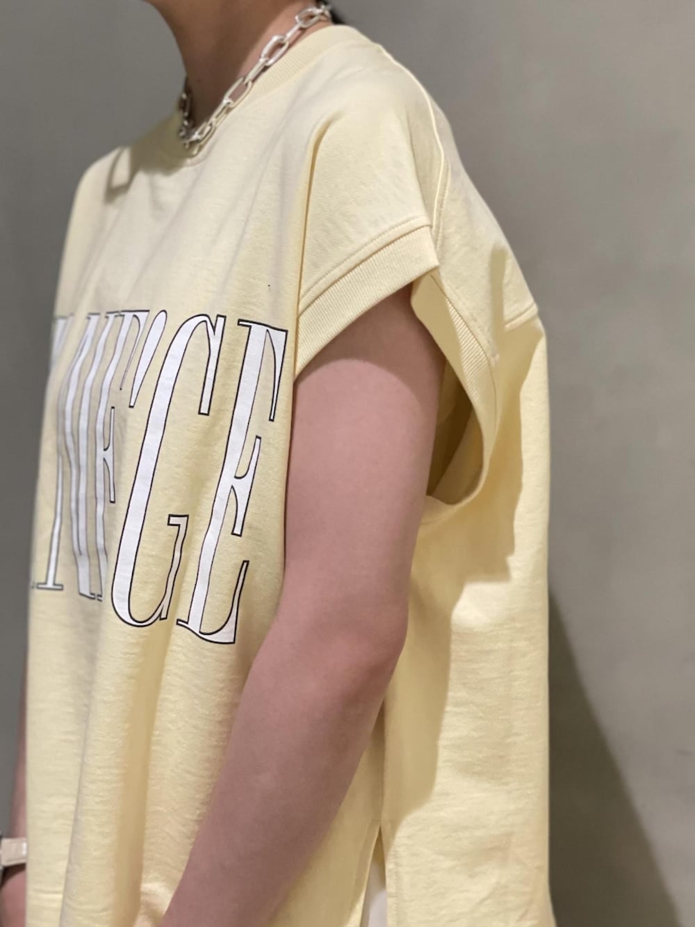 ホワイト系のワンピース、ベージュ系のTシャツ/カットソー、ブラック系のサンダルを着用したレディースの夏コーディネートの3枚目の写真